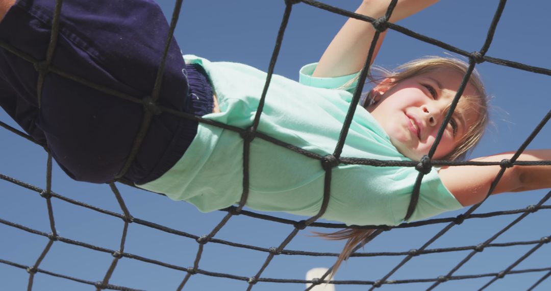 Determined Child Climbing Rope Bridge at Playground on Sunny Day - Free Images, Stock Photos and Pictures on Pikwizard.com