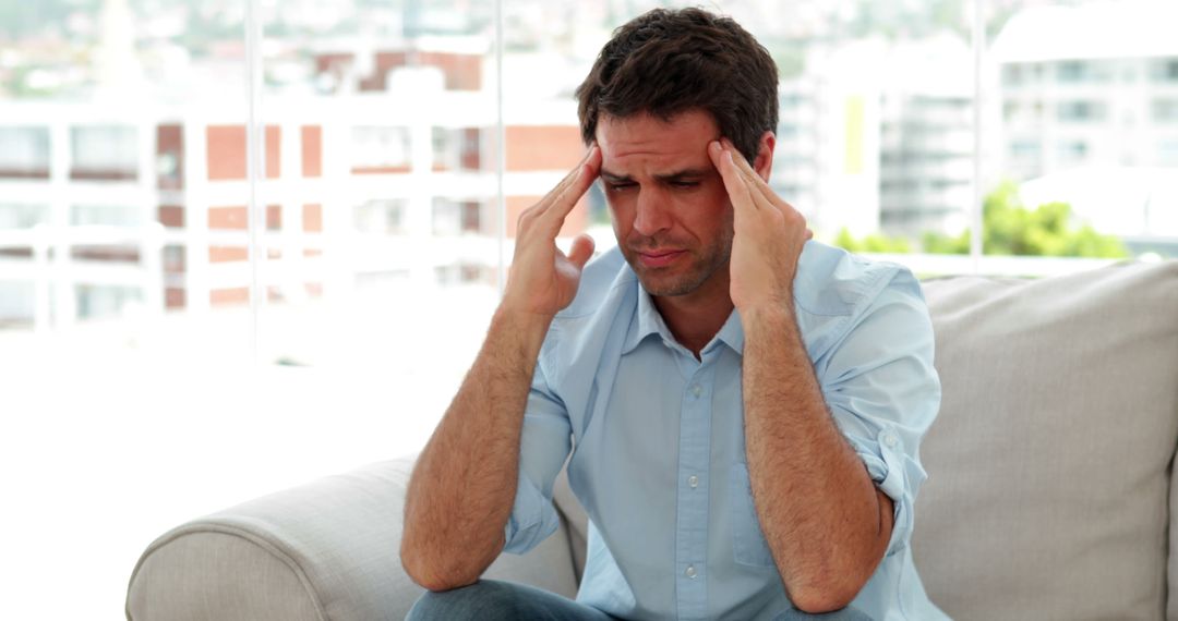 Man Holding Temples Suffering from Headache at Home - Free Images, Stock Photos and Pictures on Pikwizard.com