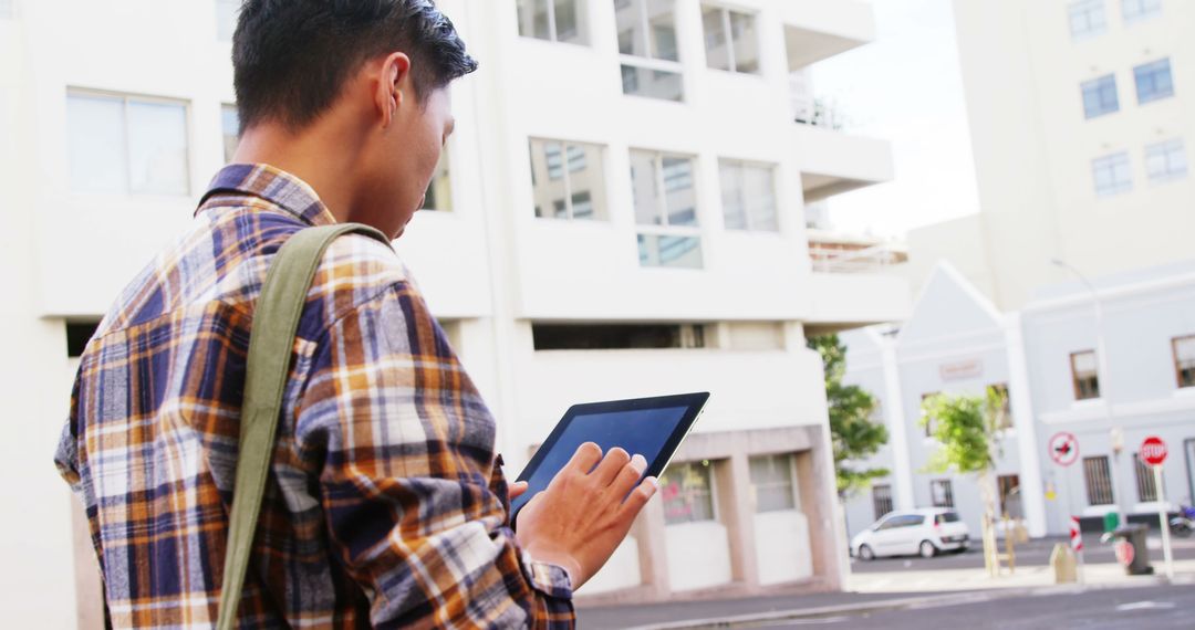 Man Checking Digital Tablet Outdoors Urban Background - Free Images, Stock Photos and Pictures on Pikwizard.com