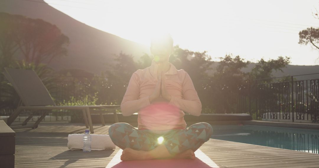 Elderly Woman Meditating Outdoors by Pool at Sunset - Free Images, Stock Photos and Pictures on Pikwizard.com