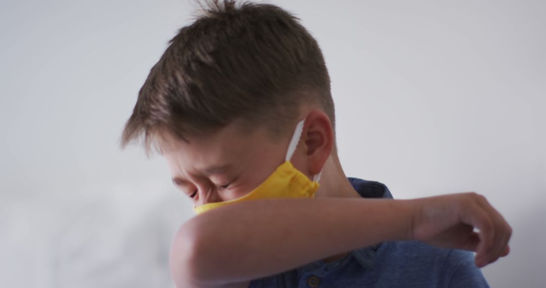 Child Coughing into Elbow Wearing Face Mask for Health Protection - Free Images, Stock Photos and Pictures on Pikwizard.com