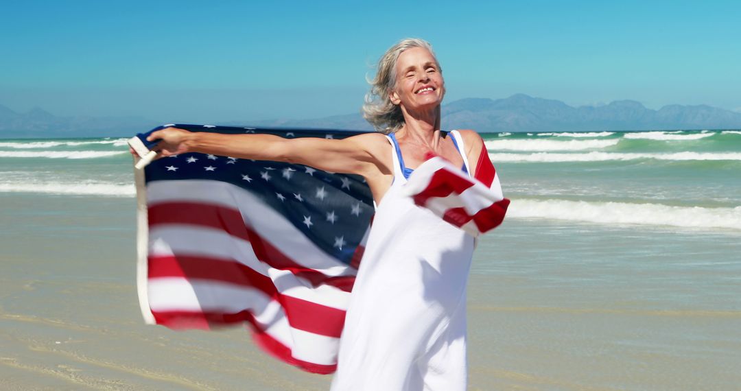 Senior Woman Celebrating at Beach with American Flag - Free Images, Stock Photos and Pictures on Pikwizard.com