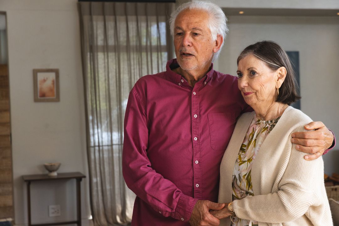 Senior Couple Embracing by Window in Cozy Home Setting