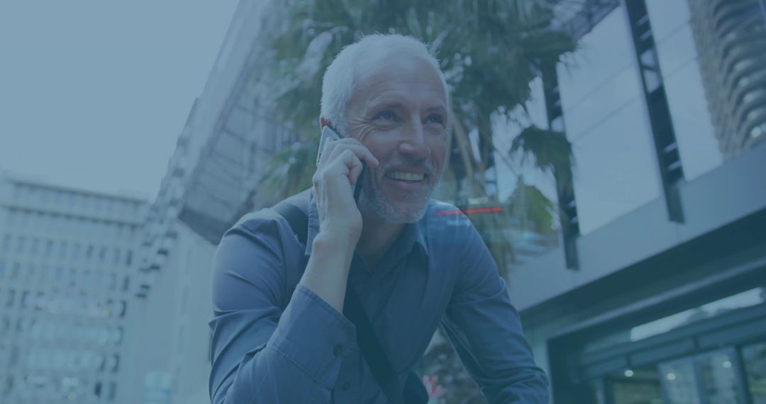 Smiling Senior Man Talking on Smartphone While Walking Downtown with Shoulder Bag