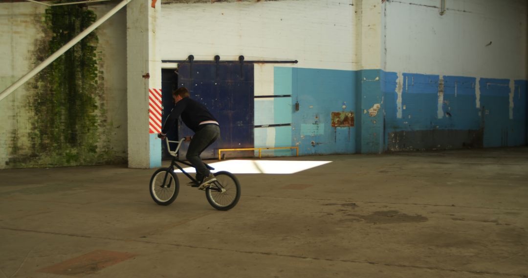 Man Practicing BMX Tricks in Abandoned Warehouse - Free Images, Stock Photos and Pictures on Pikwizard.com