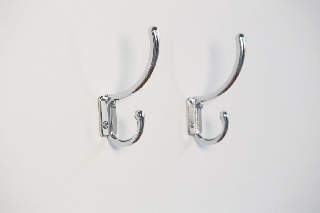 Close-Up of Empty Chrome Hooks on White Wall - Free Images, Stock Photos and Pictures on Pikwizard.com