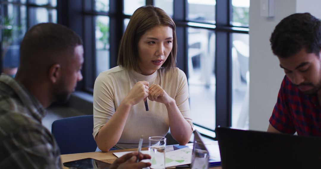 Team Collaborating in Modern Office Environment Over Plans