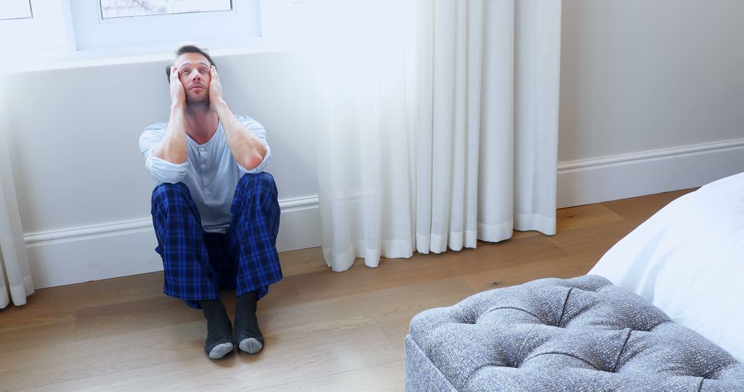 Man Sitting on Floor Appearing Stressed at Home - Free Images, Stock Photos and Pictures on Pikwizard.com