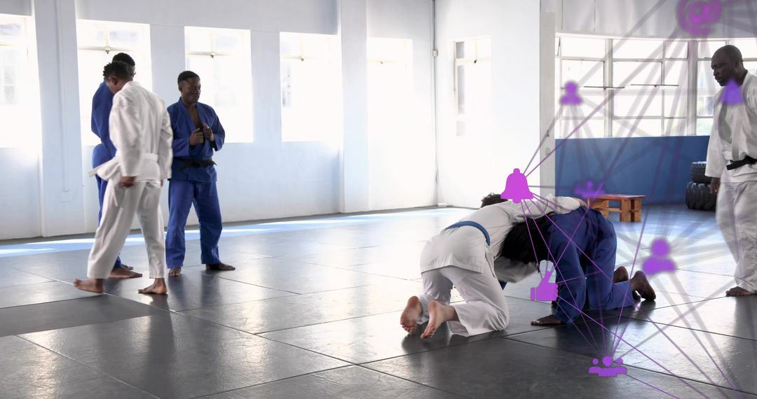 Grappling class practicing jiu-jitsu drills on padded mats in bright training studio