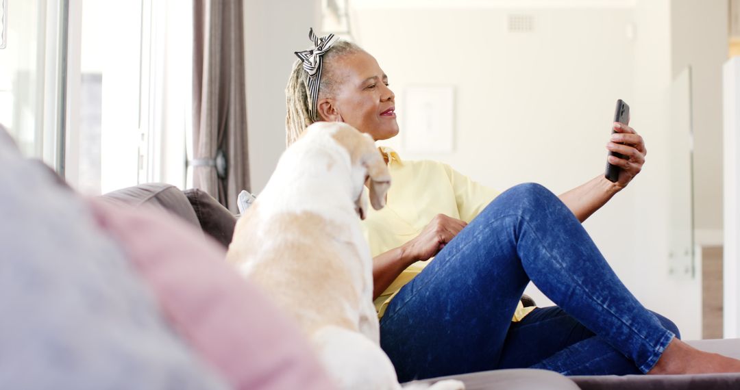 Senior Woman with Dog Relaxing while Using Smartphone