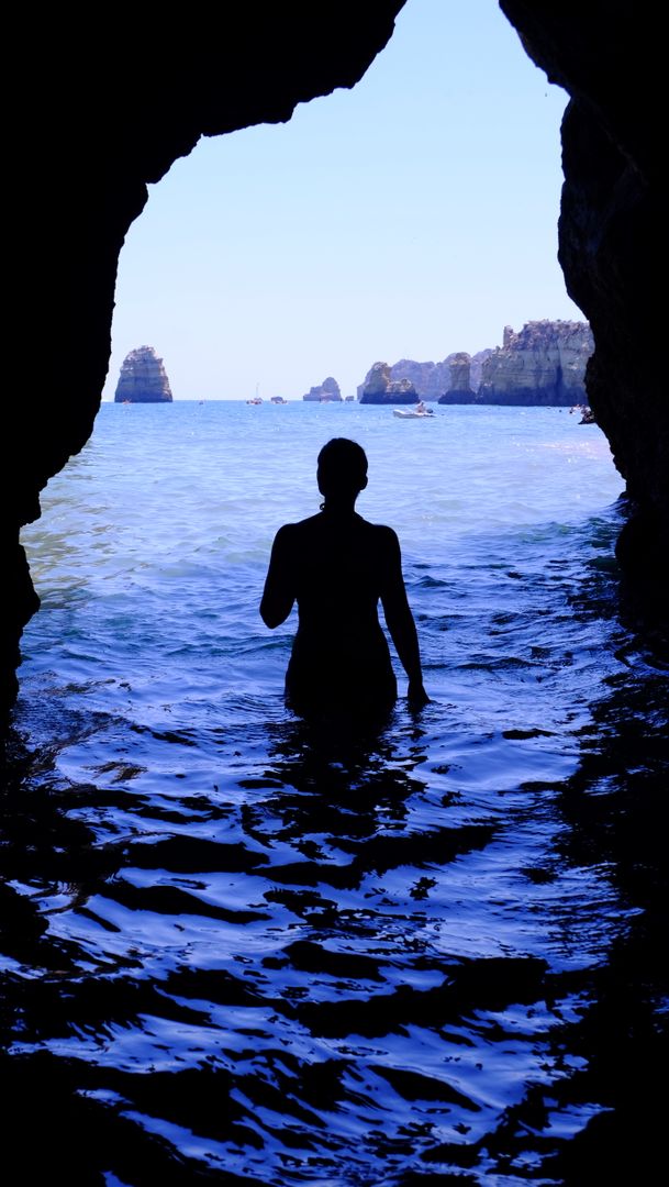 Silhouette of Woman at Blue Sea Inside Black Cave during Daytime - Free Images, Stock Photos and Pictures on Pikwizard.com