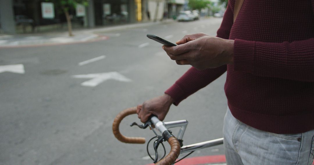 Man texting on phone while standing with bicycle in urban setting - Free Images, Stock Photos and Pictures on Pikwizard.com