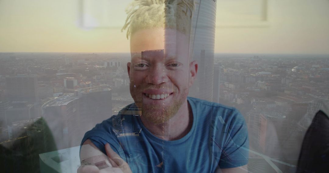 Smiling blond dreadlocked man with beard leaning by window with cityscape double exposure