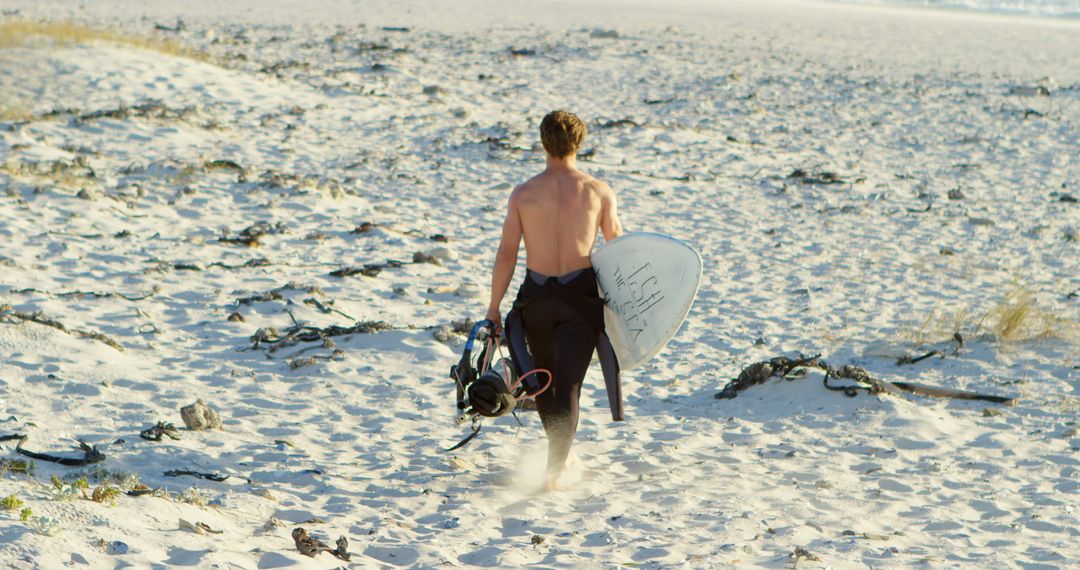 Surfer Carrying Gear Along Sandy Beach at Dawn - Free Images, Stock Photos and Pictures on Pikwizard.com