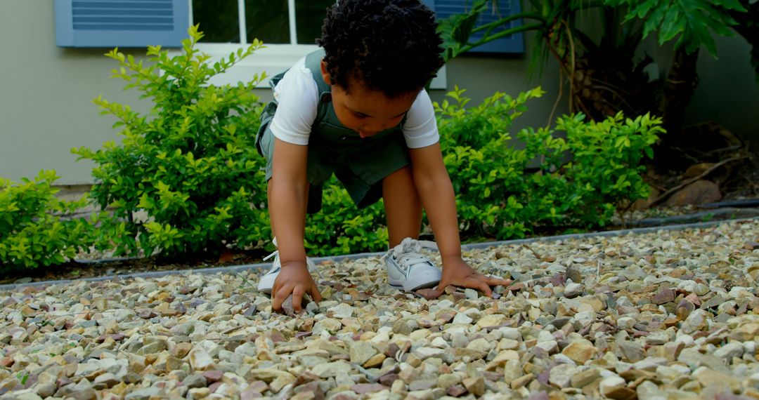 Curious Toddler Exploring Pebble Garden in Backyard - Free Images, Stock Photos and Pictures on Pikwizard.com