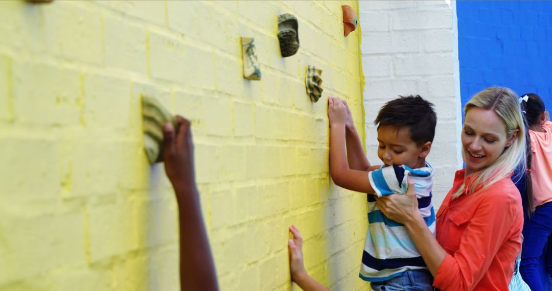 Instructor Helps Child Climbing Wall Indoors - Free Images, Stock Photos and Pictures on Pikwizard.com