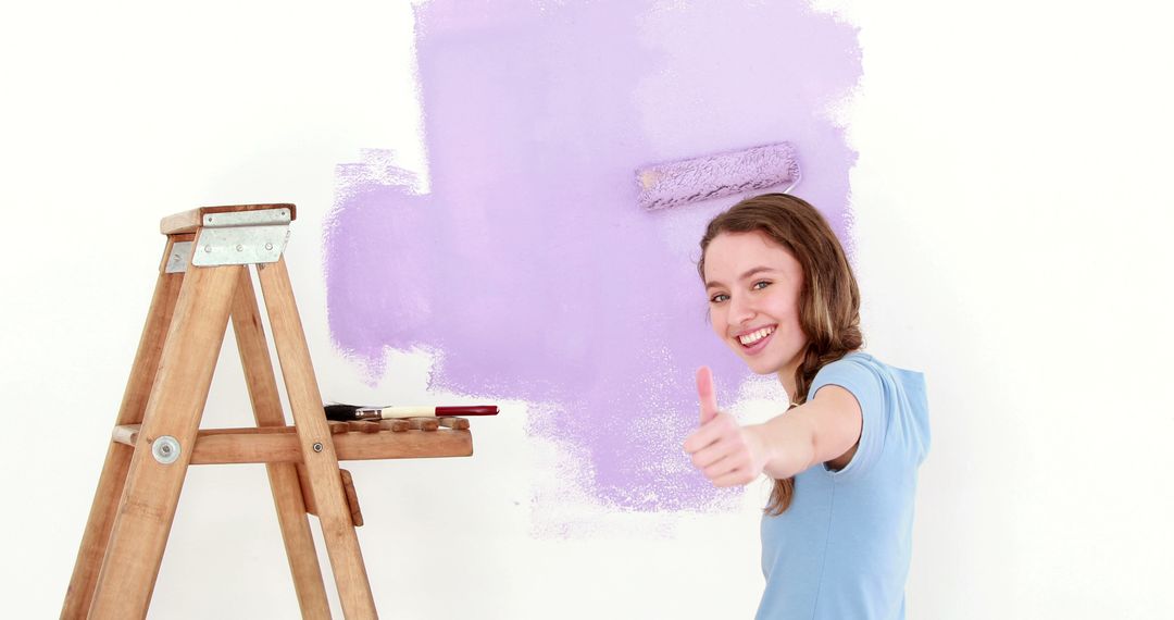 Young Girl Painting Wall Light Purple Giving Thumbs Up - Free Images, Stock Photos and Pictures on Pikwizard.com