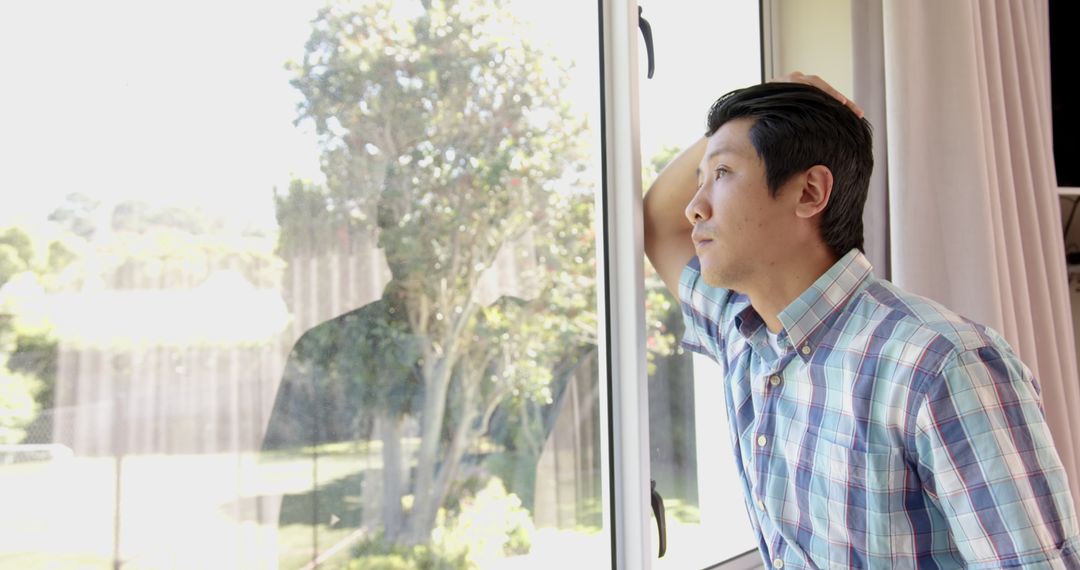 Man Standing by Window Contemplating Peaceful Garden Serenity
