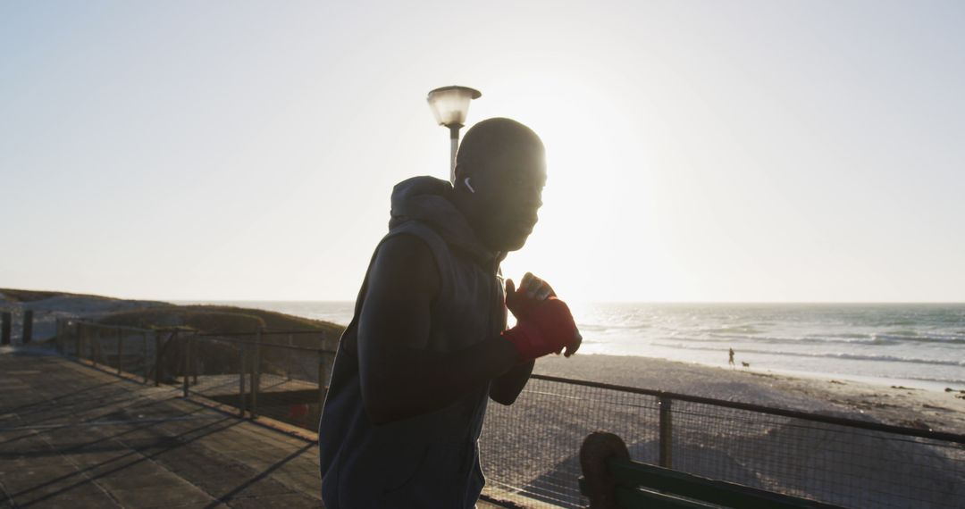 Determined Man Shadowboxing at Sunset on Beachfront - Free Images, Stock Photos and Pictures on Pikwizard.com