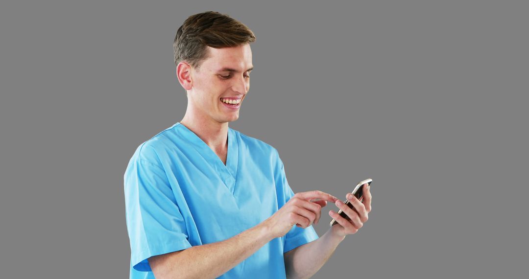 Smiling Male Doctor Using Smartphone on Gray Background - Free Images, Stock Photos and Pictures on Pikwizard.com