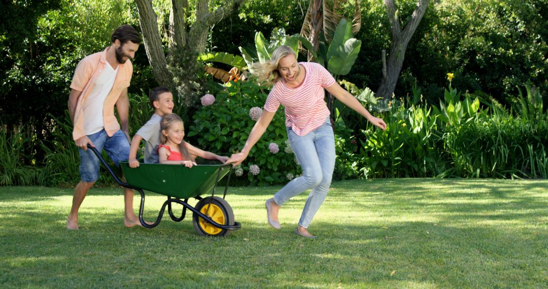 Happy Family Playing with Wheelbarrow in Sunny Garden - Free Images, Stock Photos and Pictures on Pikwizard.com