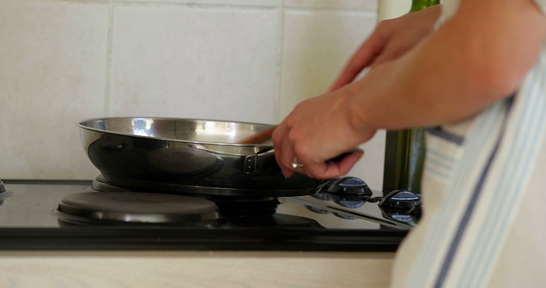 Woman Cooking on Stove with Frying Pan in Home Kitchen - Free Images, Stock Photos and Pictures on Pikwizard.com