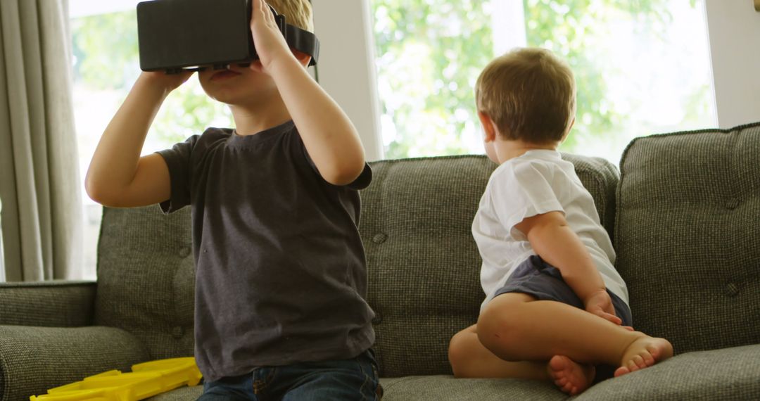 Children Playing with Virtual Reality on Sofa on Bright Day - Free Images, Stock Photos and Pictures on Pikwizard.com