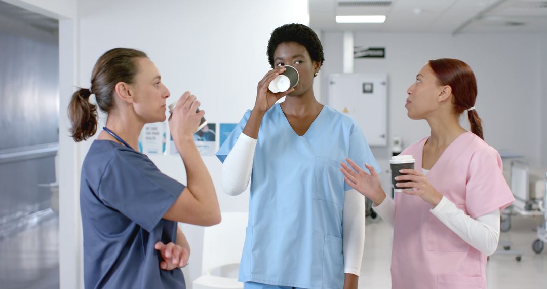 Healthcare Professionals Taking Coffee Break in Hospital Corridor - Free Images, Stock Photos and Pictures on Pikwizard.com