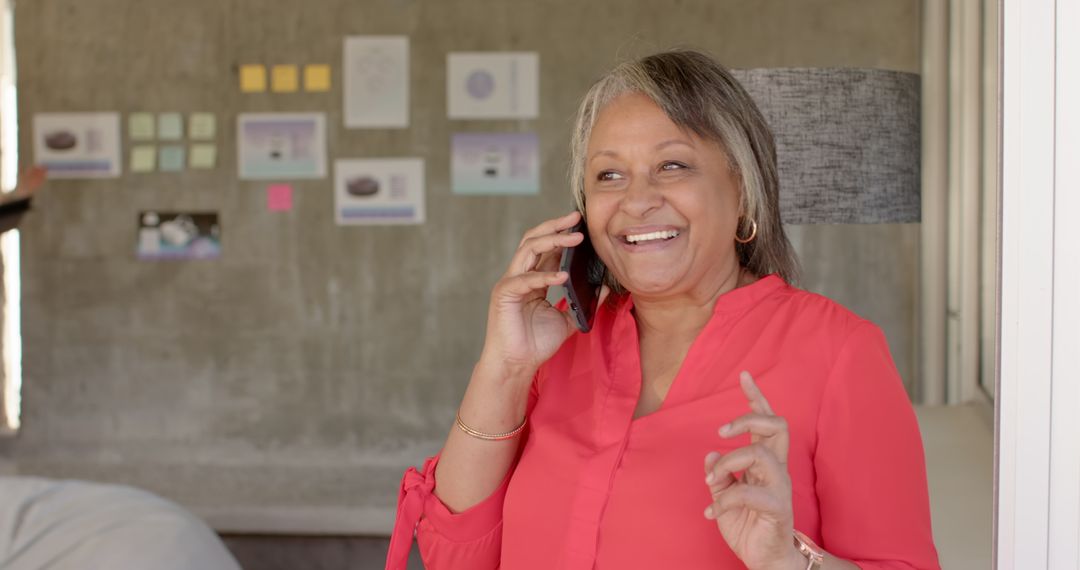 Senior Woman Smiling While Talking on Smartphone in Modern Office