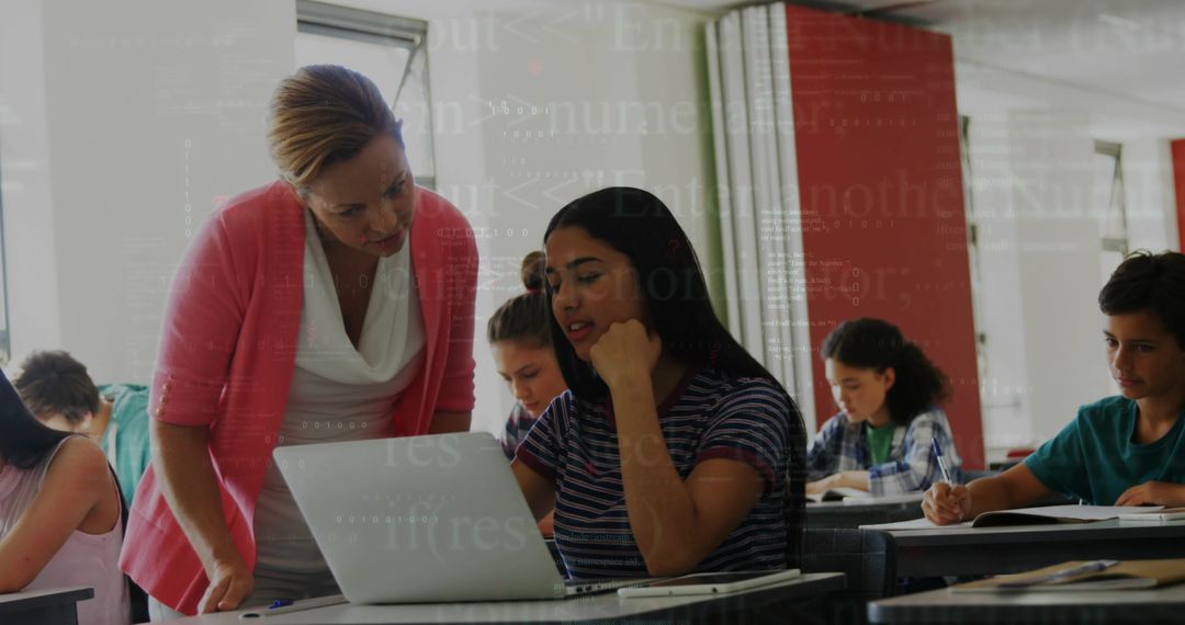 Teacher Guiding Student Using Laptop in Collaborative Modern Classroom
