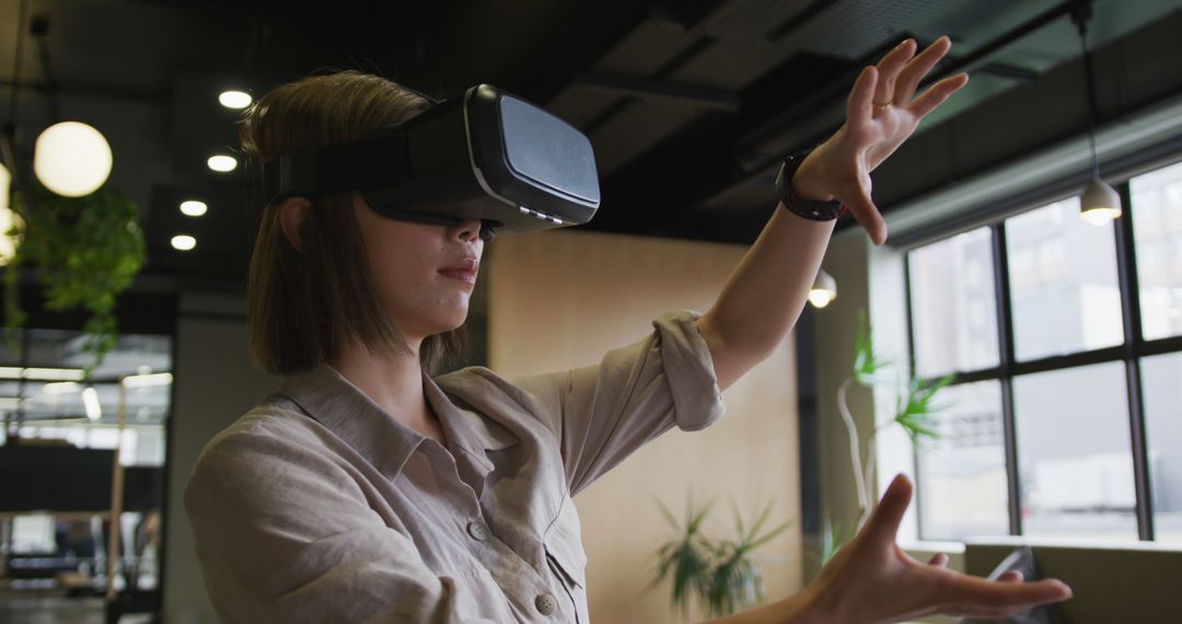 Woman Engaging with Virtual Reality Technology in Modern Office - Free Images, Stock Photos and Pictures on Pikwizard.com