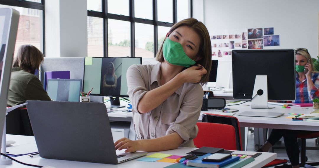 Asian Woman Removing Mask in Modern Office Environment