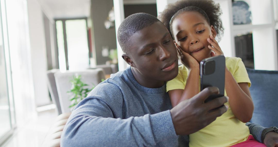 Image of african american father and daughter using smartphone - Free Images, Stock Photos and Pictures on Pikwizard.com