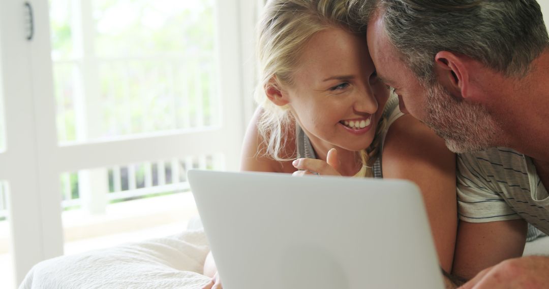 Joyful Caucasian Couple Bonding While Using Laptop at Home