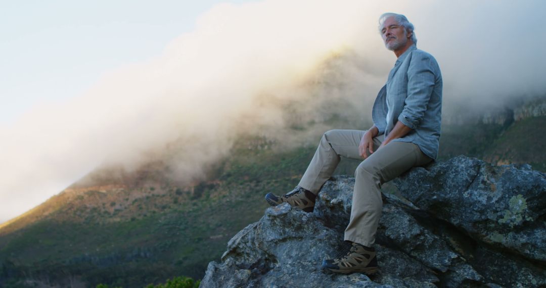 Elderly Man Enjoying Scenic Mountain View at Dusk