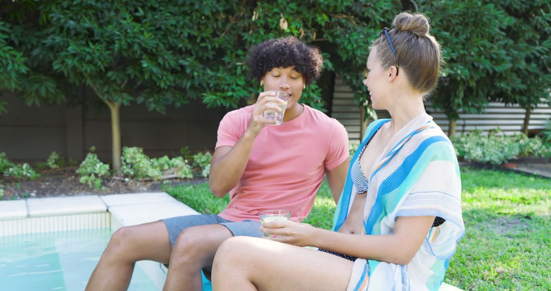 Diverse Couple Relaxing by Poolside with Refreshing Drinks Outdoors