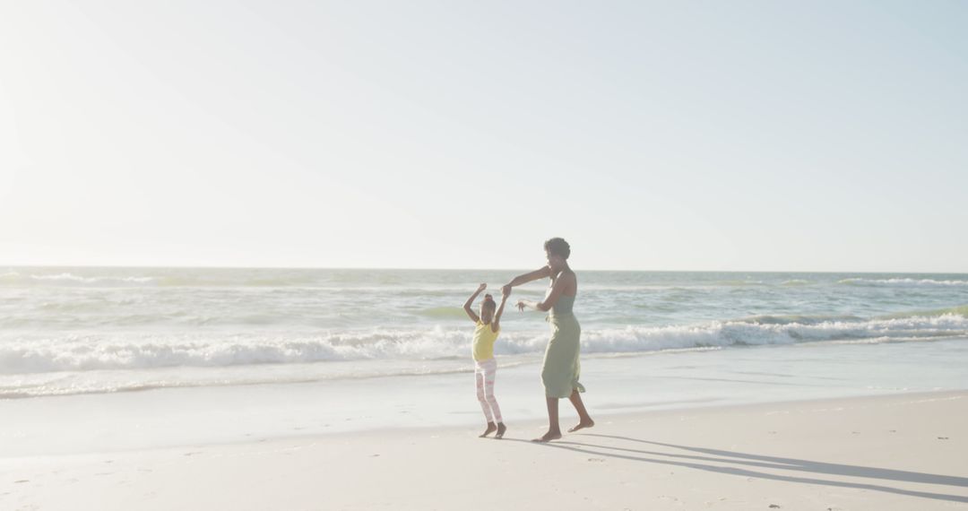 Mother and Daughter Dancing on Sunny Beach - Free Images, Stock Photos and Pictures on Pikwizard.com