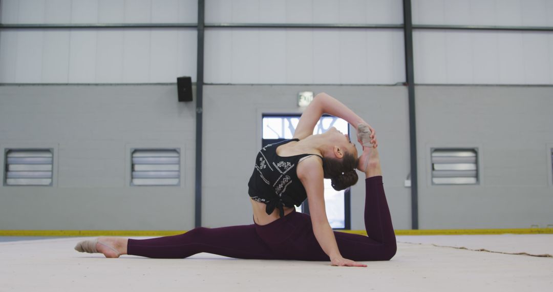 Young Female Athlete Performing Floor Exercise Stretch in Gym - Free Images, Stock Photos and Pictures on Pikwizard.com