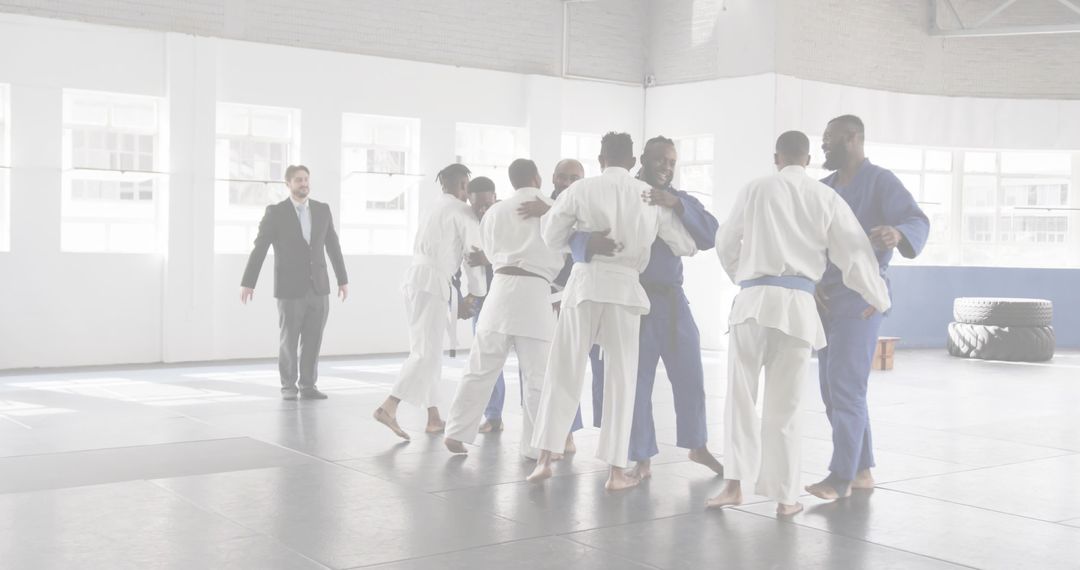 Hugging martial artists celebrating teamwork and camaraderie after jiu-jitsu training