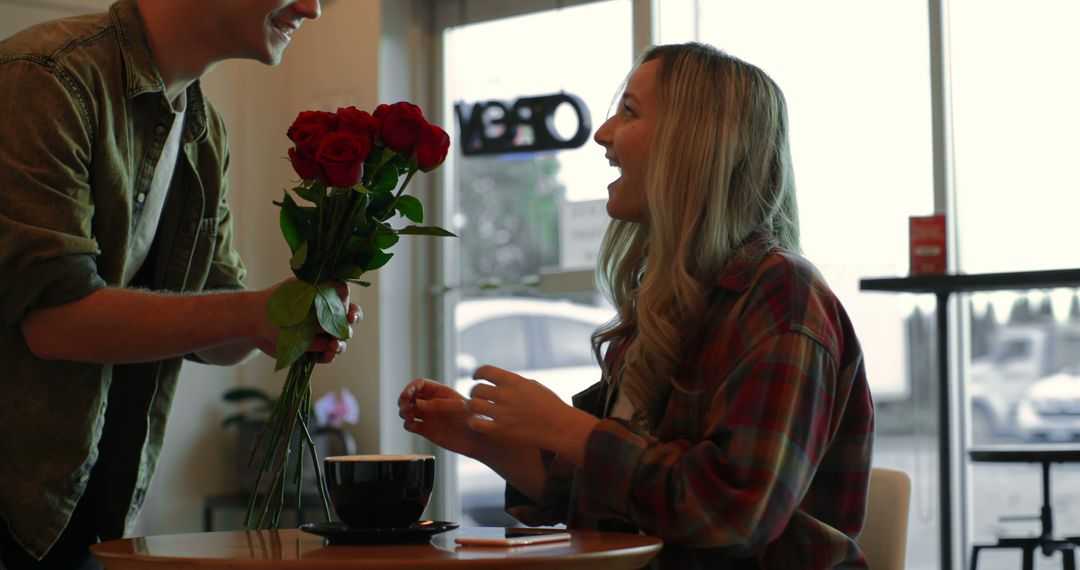 Man surprising woman with roses at cozy cafe - Free Images, Stock Photos and Pictures on Pikwizard.com