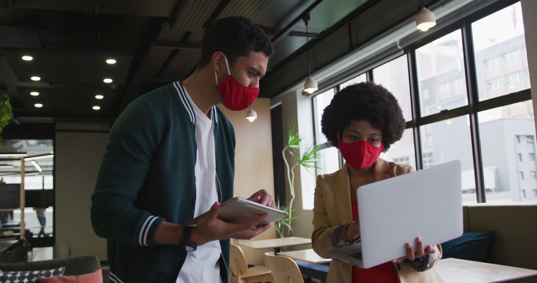 Colleagues Collaborating with Technology in Modern Office Space