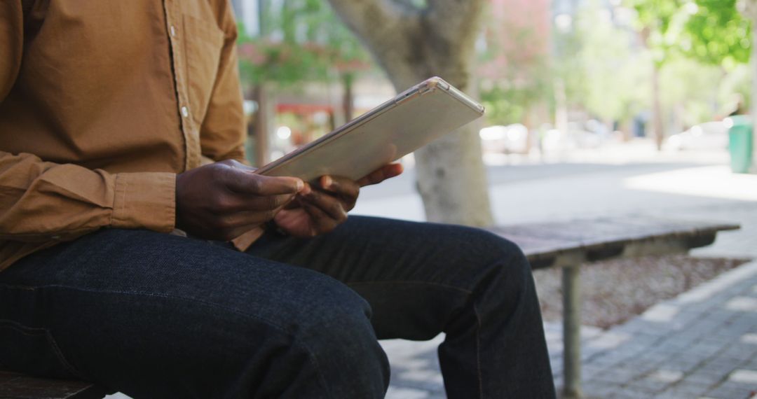 Man Holding Tablet in Urban Outdoor Setting - Free Images, Stock Photos and Pictures on Pikwizard.com