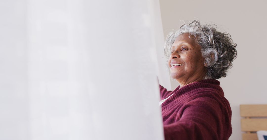 Senior Woman Opening Curtains and Smiling Joyfully - Free Images, Stock Photos and Pictures on Pikwizard.com