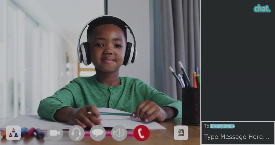 Elementary boy wearing headphones studying and focusing during remote learning at desk