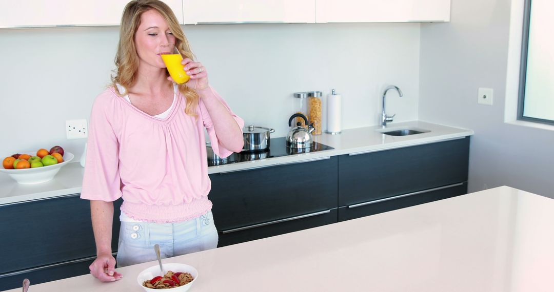 Woman Drinking Juice in Modern Kitchen - Free Images, Stock Photos and Pictures on Pikwizard.com