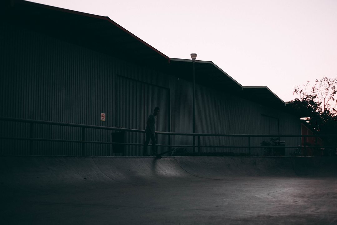Single Skateboarder in Empty Skatepark at Dusk
