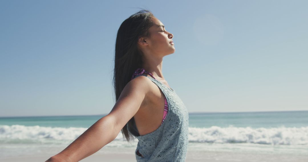 Asian woman closing eyes and standing on beach - Free Images, Stock Photos and Pictures on Pikwizard.com