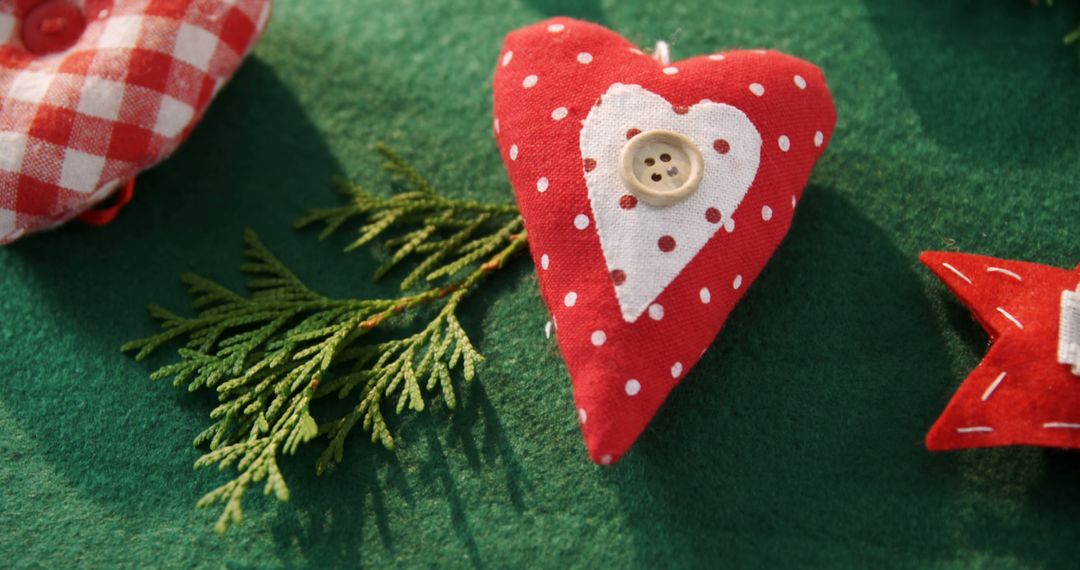 A red heart with a button on a green backdrop hints at Christmas or craft use. - Free Images, Stock Photos and Pictures on Pikwizard.com