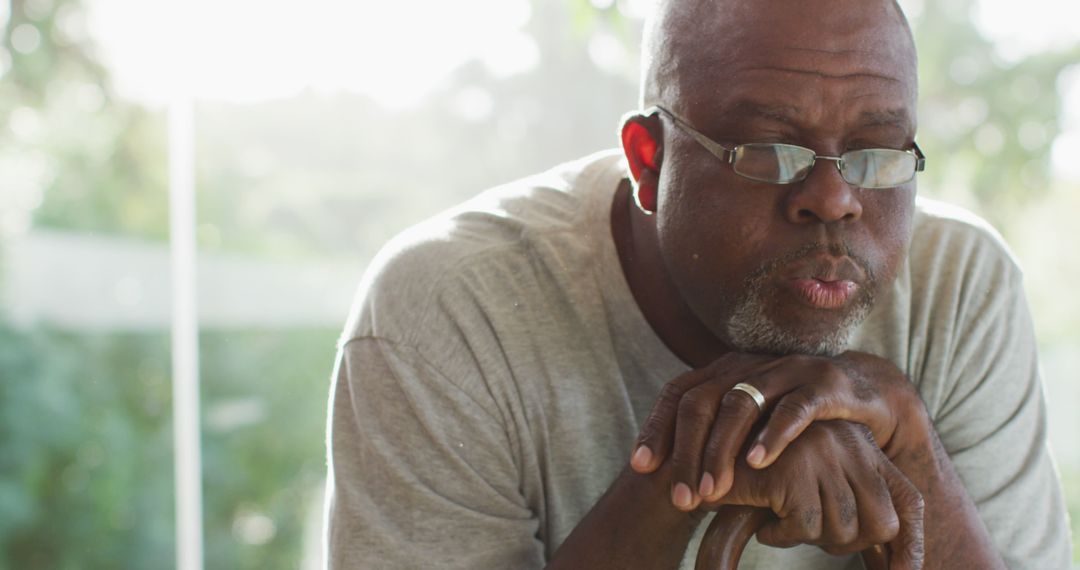 Elderly Man Wearing Glasses Looking Thoughtful Holding Cane - Free Images, Stock Photos and Pictures on Pikwizard.com