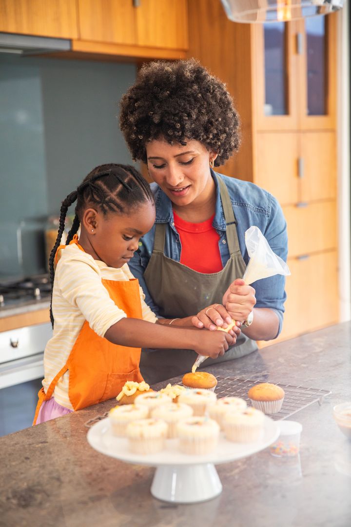Mother and Daughter Bonding While Baking Cupcakes at Home